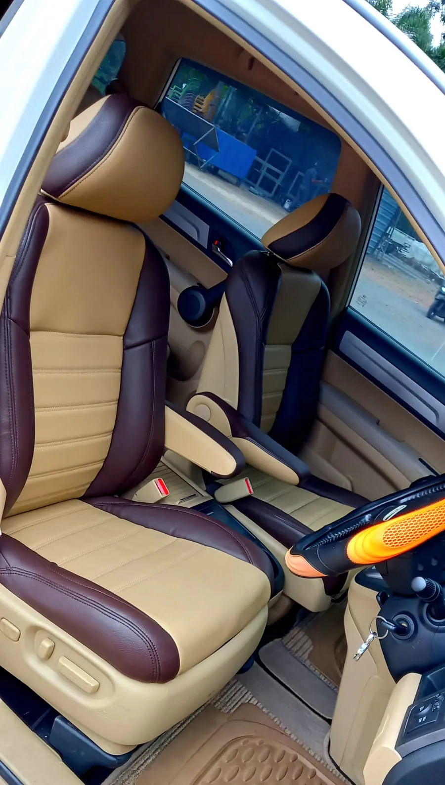 Jok depan mobil krem dengan panel cokelat