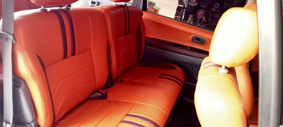 Jok mobil oranye dengan garis hitam di kabin