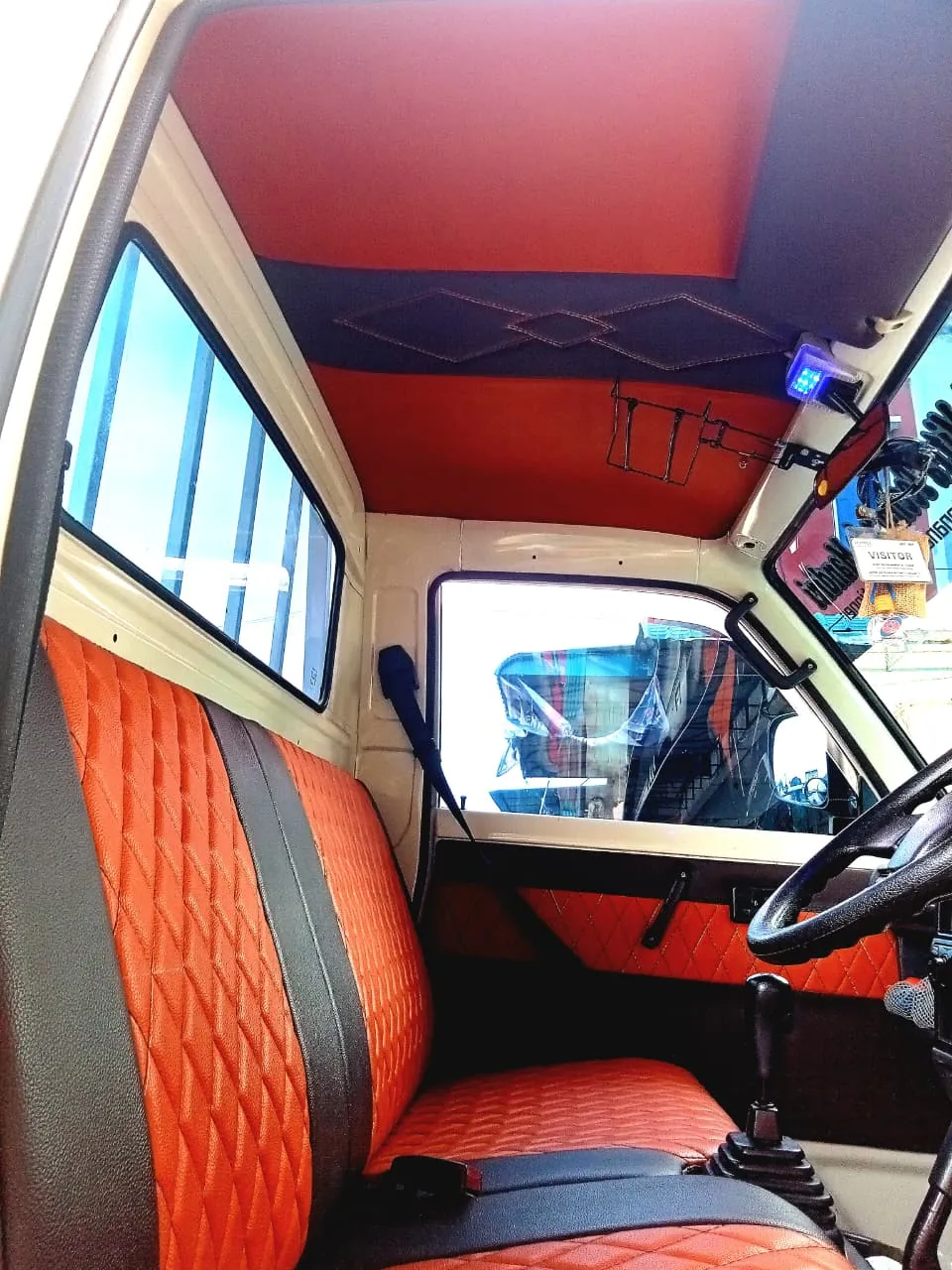 Kabin mobil pikap dengan jok dan plafon oranye berjahit belah ketupat