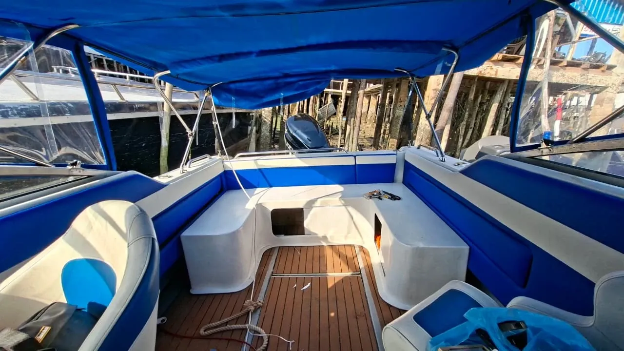 Interior speedboat setelah pengerjaan: sandaran dan dudukan biru-putih, kanopi canvas biru dengan jendela bening